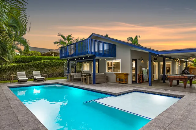 a view of a house with swimming pool and sitting area