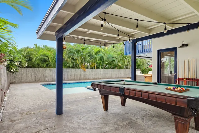 a room with pool table and windows