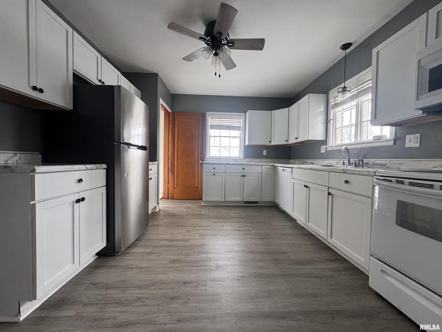 602 Washington Avenue Lowden, IA 52255 - Photo 12 of 28 a kitchen with granite countertop white cabinets and white appliances