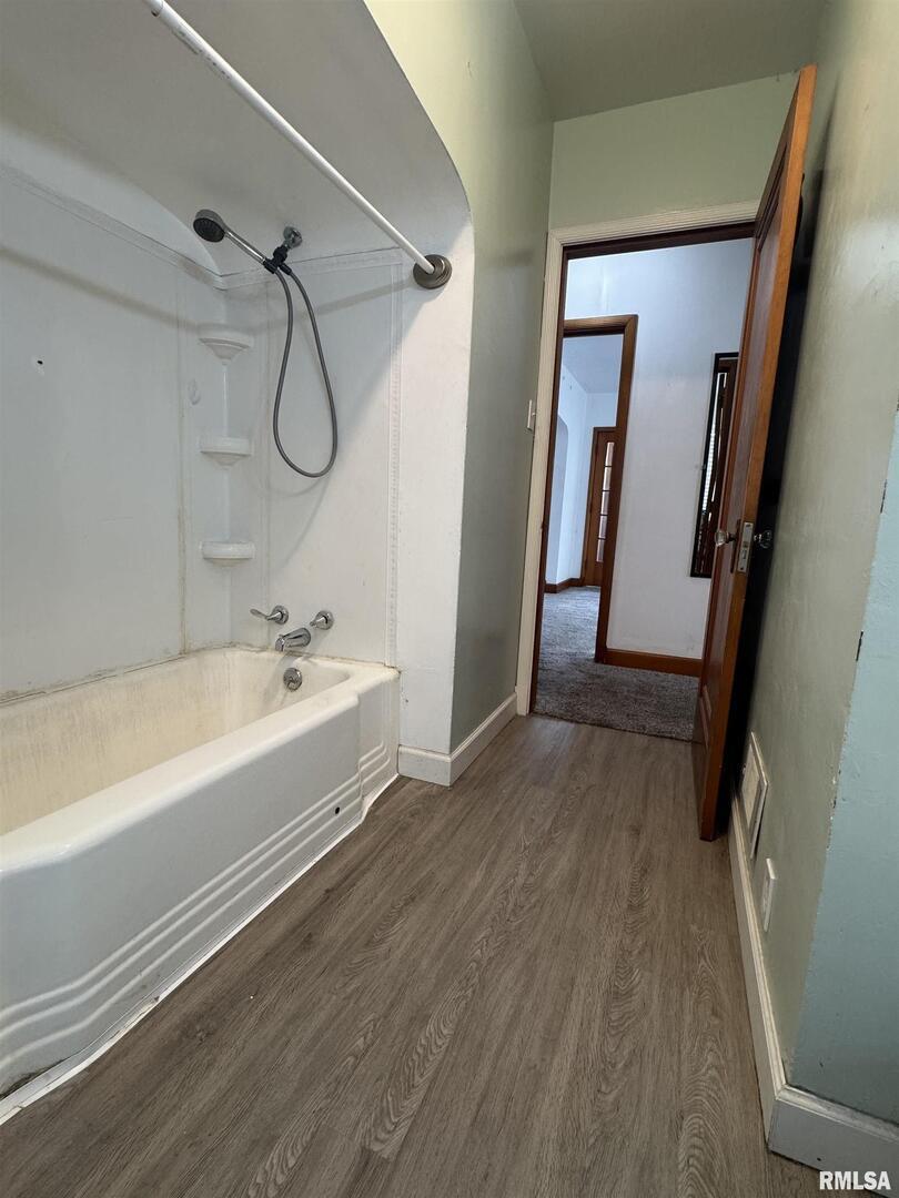602 Washington Avenue Lowden, IA 52255 - Photo 18 of 28 a bathroom with a tub sink a mirror and shower