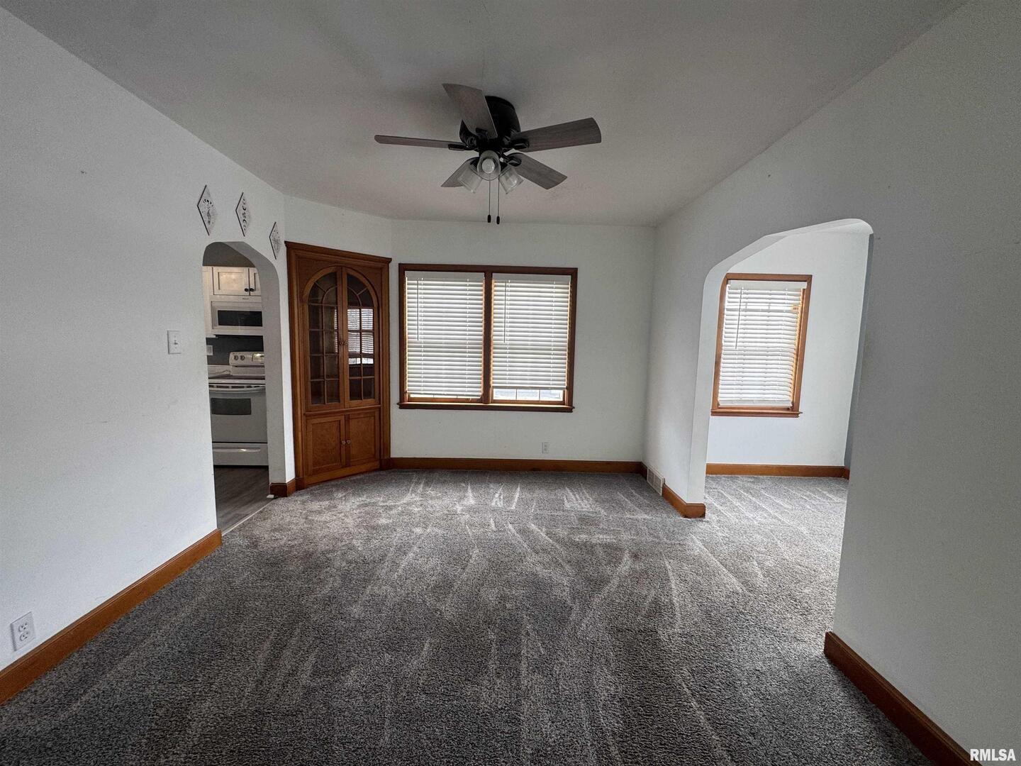 602 Washington Avenue Lowden, IA 52255 - Photo 8 of 28 an empty room with windows and ceiling fan