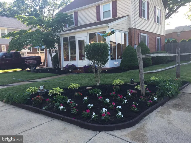 a front view of a house with a yard and garden