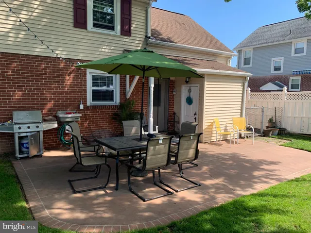 a view of a backyard with chairs and table in a patio