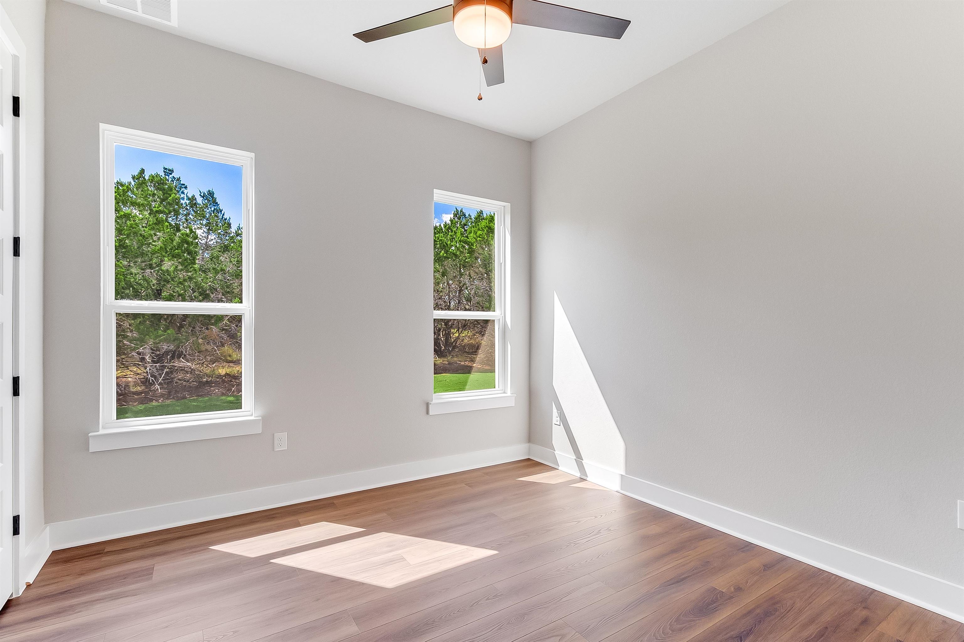 179 Rosebud Rnch Road Bertram, TX 78605 - Photo 23 of 28 a view of an empty room with wooden floor and a window