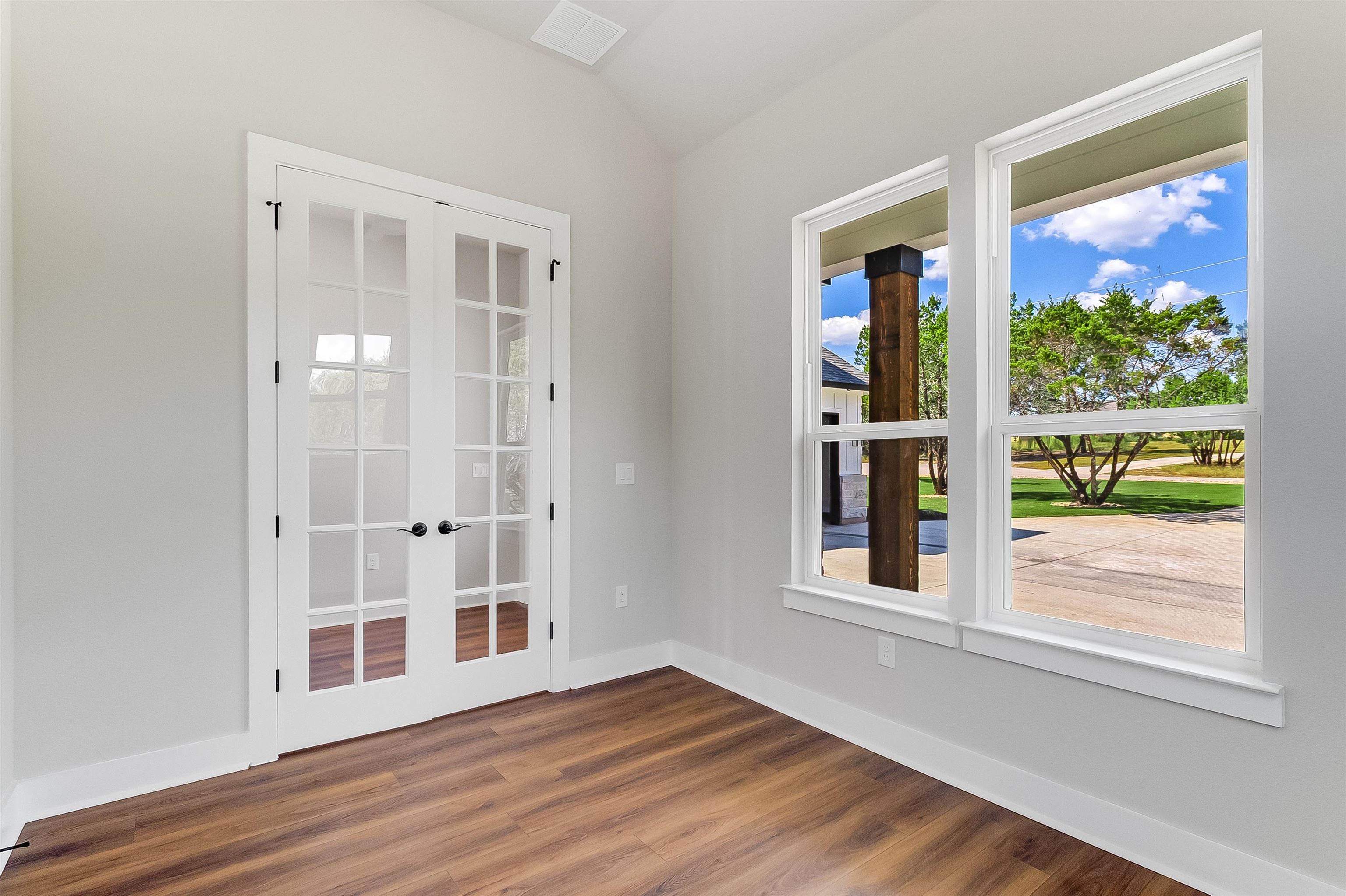 179 Rosebud Rnch Road Bertram, TX 78605 - Photo 4 of 28 a view of an empty room with wooden floor and windows