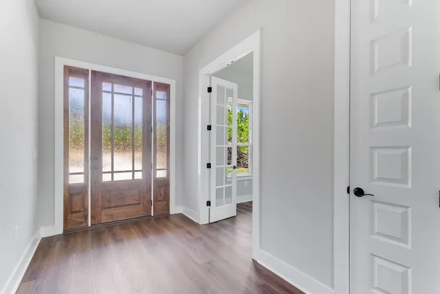 an empty room with wooden floor and windows