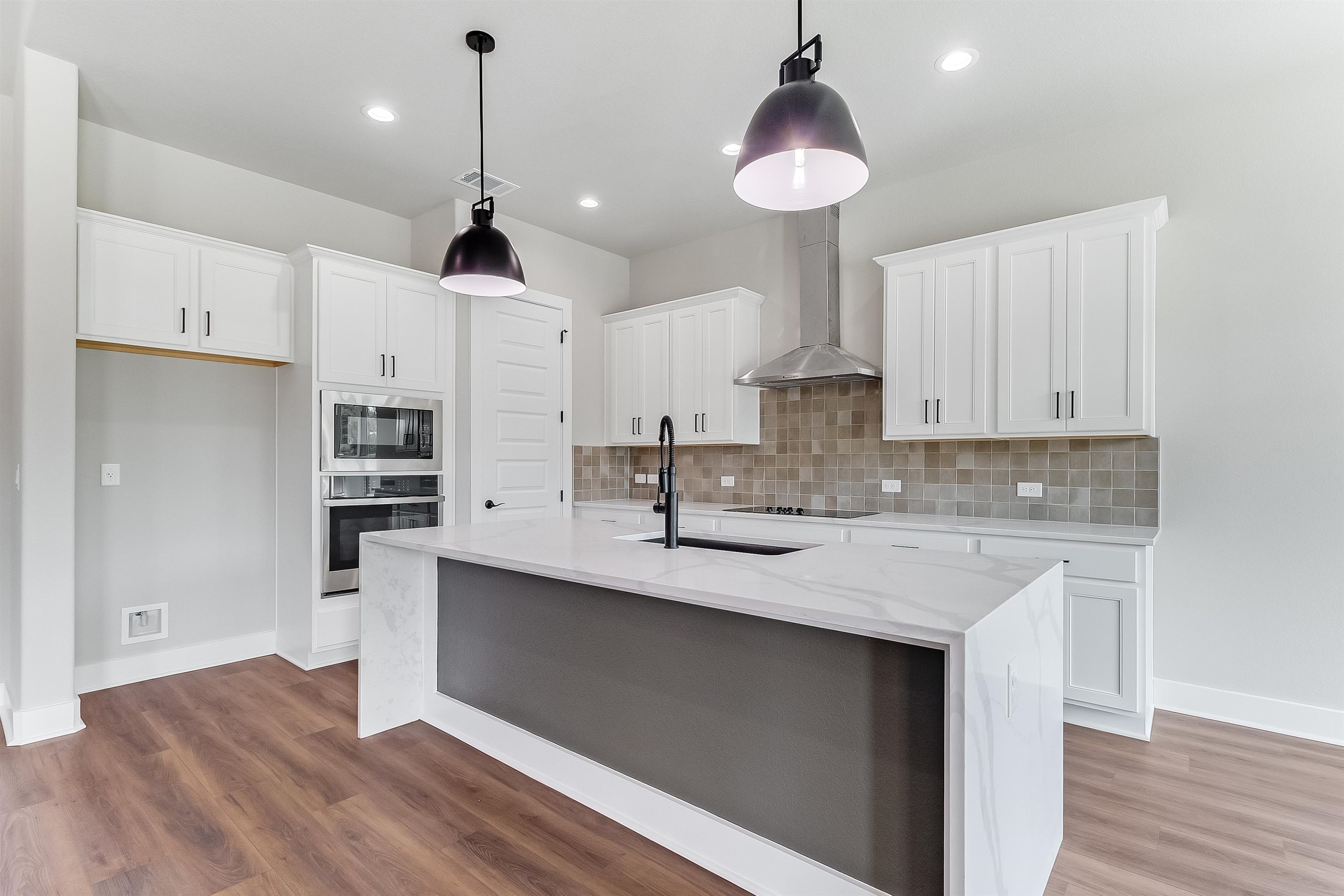179 Rosebud Rnch Road Bertram, TX 78605 - Photo 7 of 28 a kitchen with stainless steel appliances granite countertop a sink a stove a refrigerator and island with wooden floor