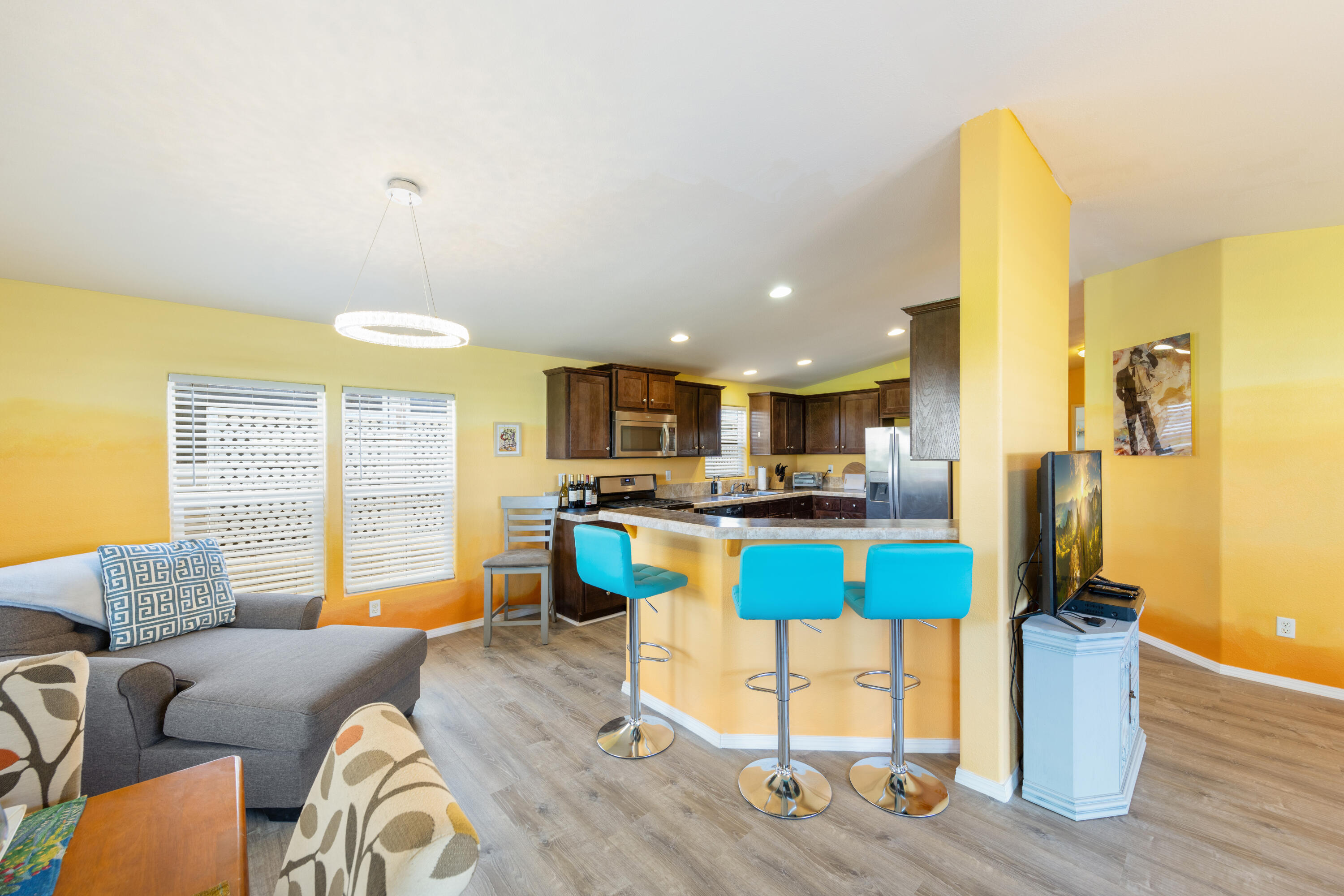 15500 Bubbling Wells Road, Unit 243 Desert Hot Springs, CA 92240 - Photo 6 of 39 a living room with furniture a wooden floor and kitchen view