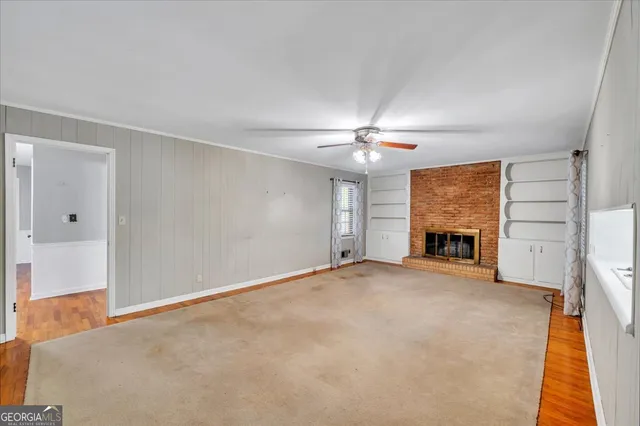 an empty room with fireplace and windows
