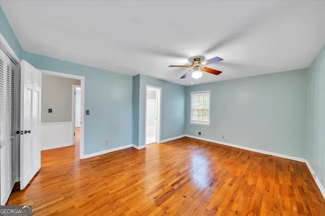 a view of empty room with wooden floor