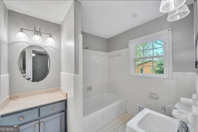 a bathroom with a toilet a sink a mirror and bathtub