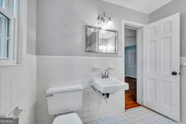 a bathroom with a toilet a sink and mirror