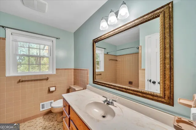a bathroom with a sink a toilet and mirror