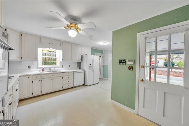 a large white kitchen with a window