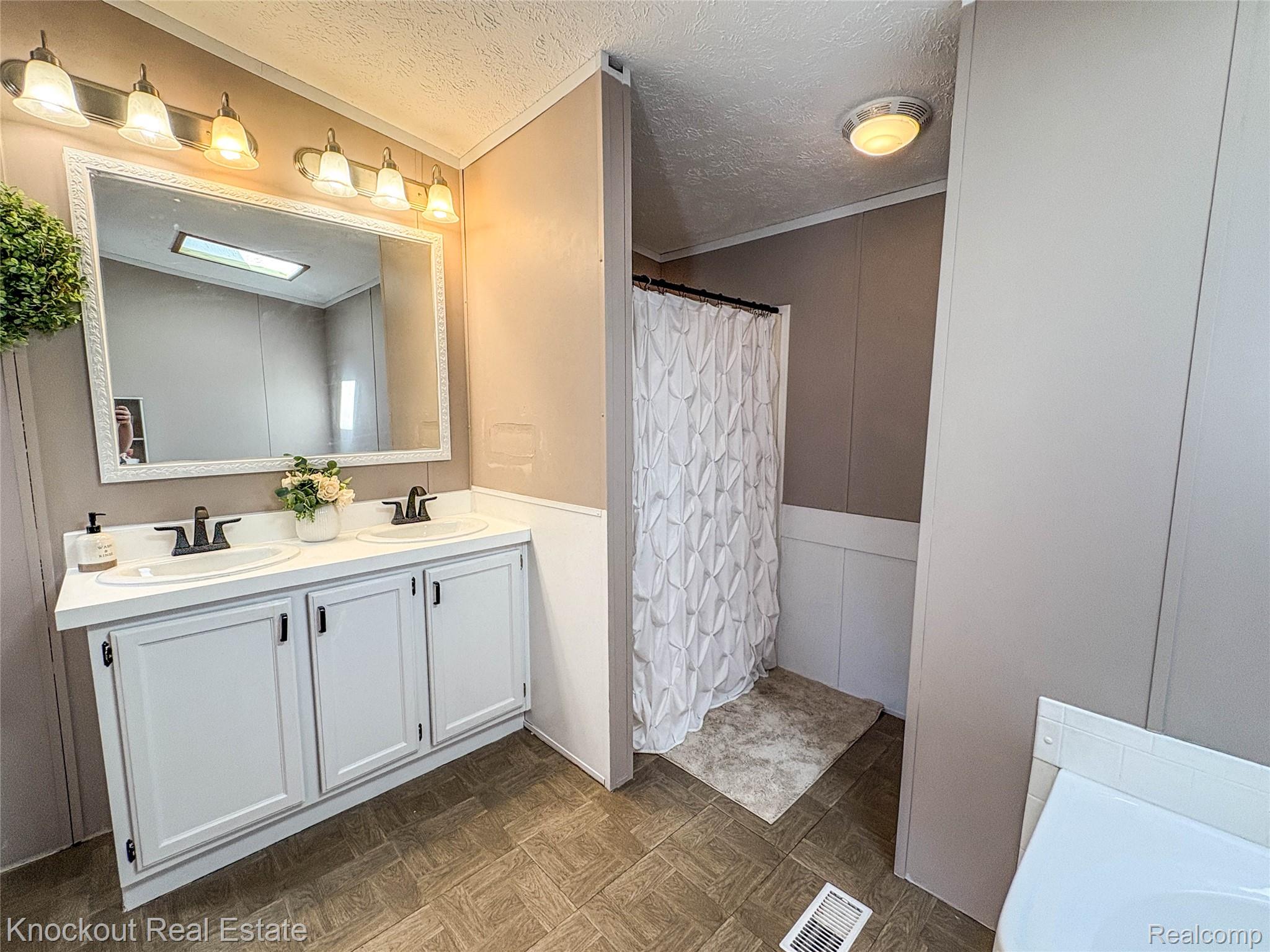7760 Bell Road Birch Run, MI 48415 - Photo 33 of 68 Double vanity with white cabinetry and black hardware