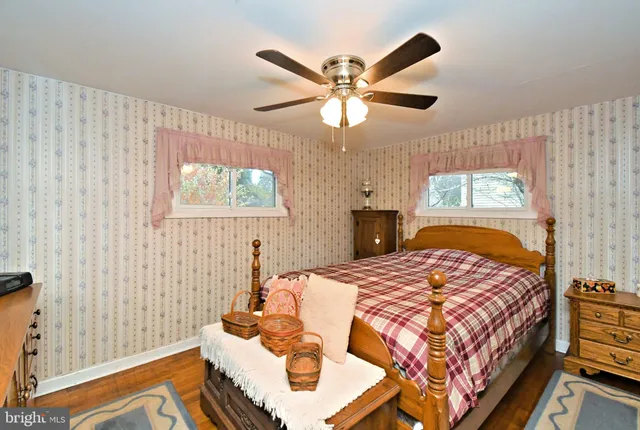 a bedroom with a bed and a large mirror on the dresser