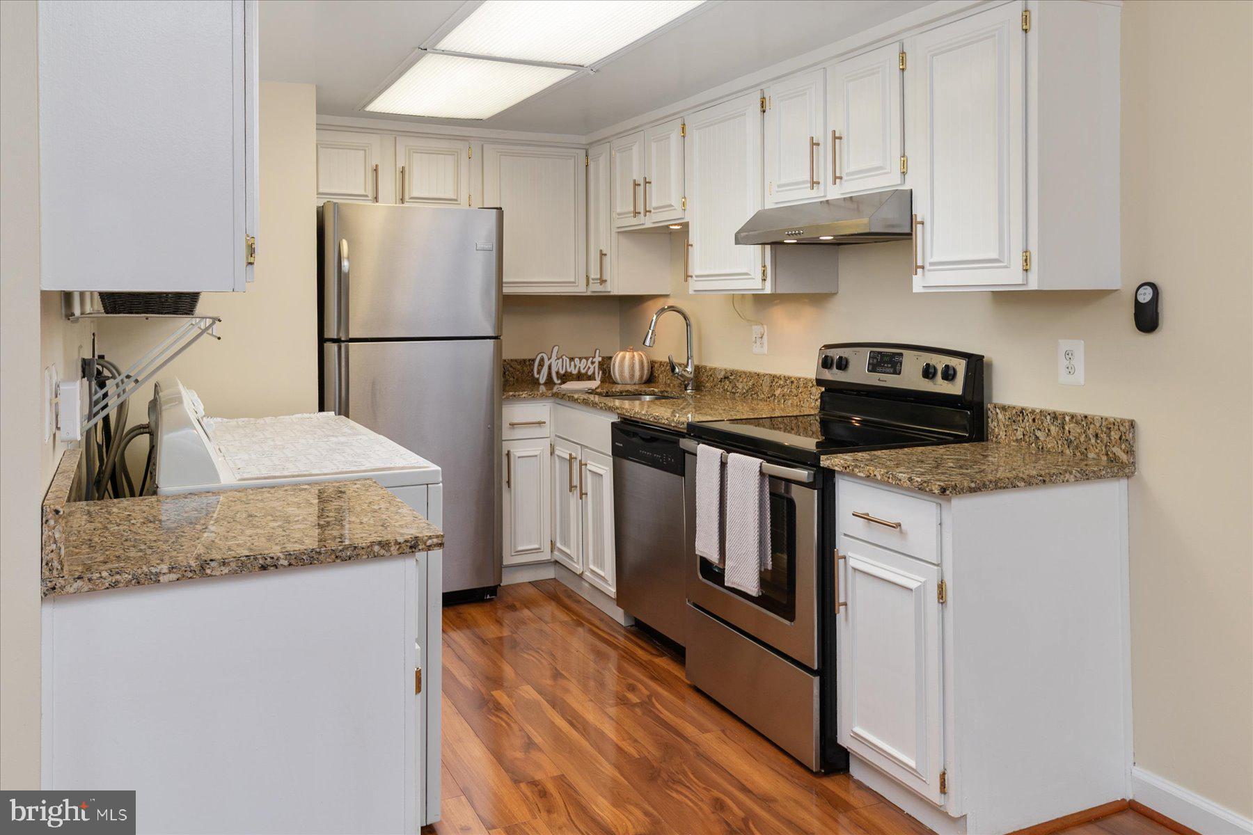1914 Ardenwood Terrace Crofton, MD 21114 - Photo 12 of 34 a kitchen with stainless steel appliances granite countertop a refrigerator sink stove and white cabinets