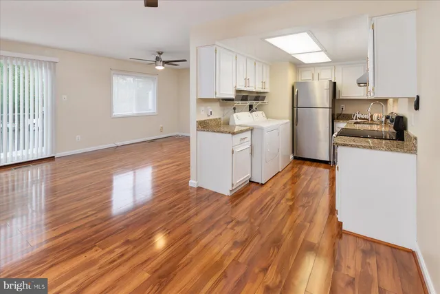a kitchen with wooden floors and white appliances