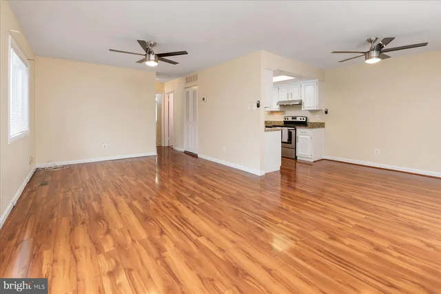 a view of empty room with wooden floor