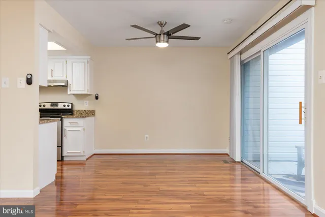 a view of a kitchen with wooden floor and a ceiling fan