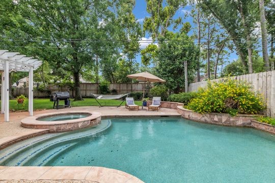 8723 Kennet Valley Road Spring, TX 77379 - Photo 2 of 38 a view of a swimming pool with a table and chairs under an umbrella