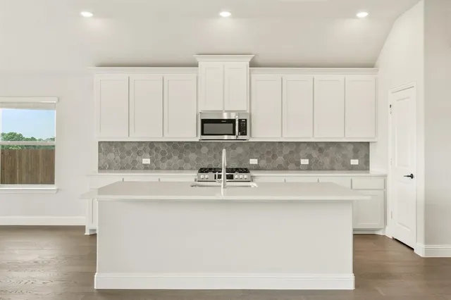 a view of a kitchen with granite countertop white cabinets and a stainless steel appliances