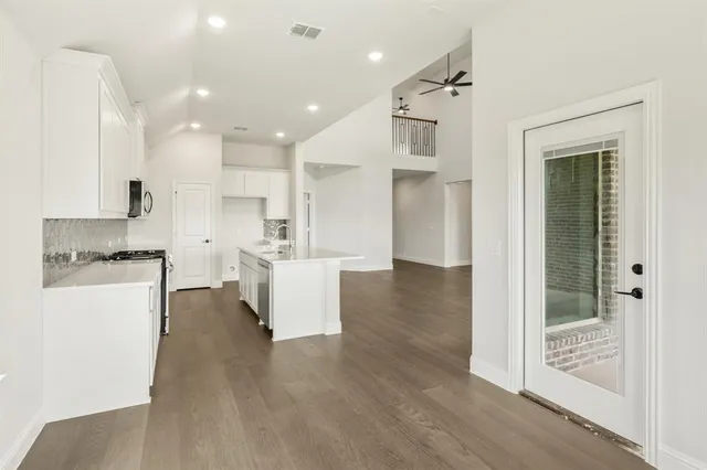 a view of kitchen with kitchen island and stainless steel appliances