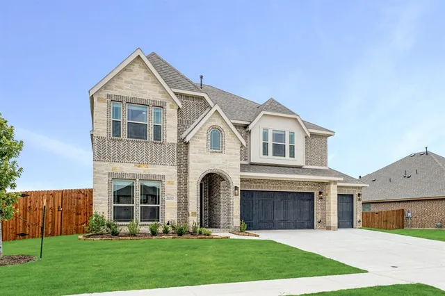 a front view of a house with a yard and trees