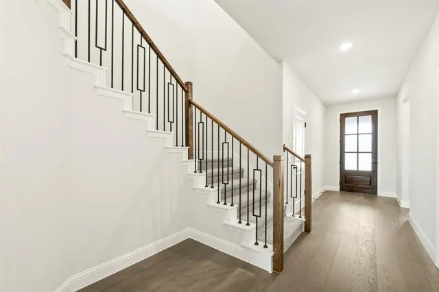 a view of a hallway with wooden floor and staircase
