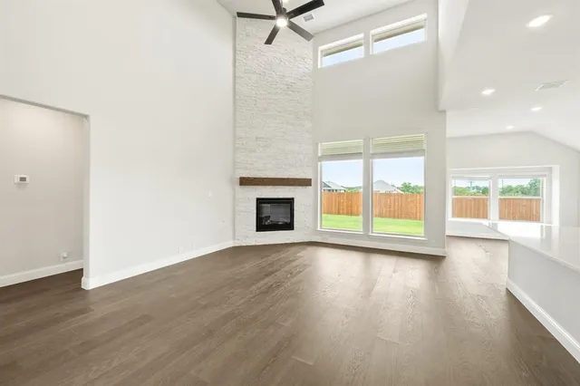wooden floor fireplace and windows in an empty room