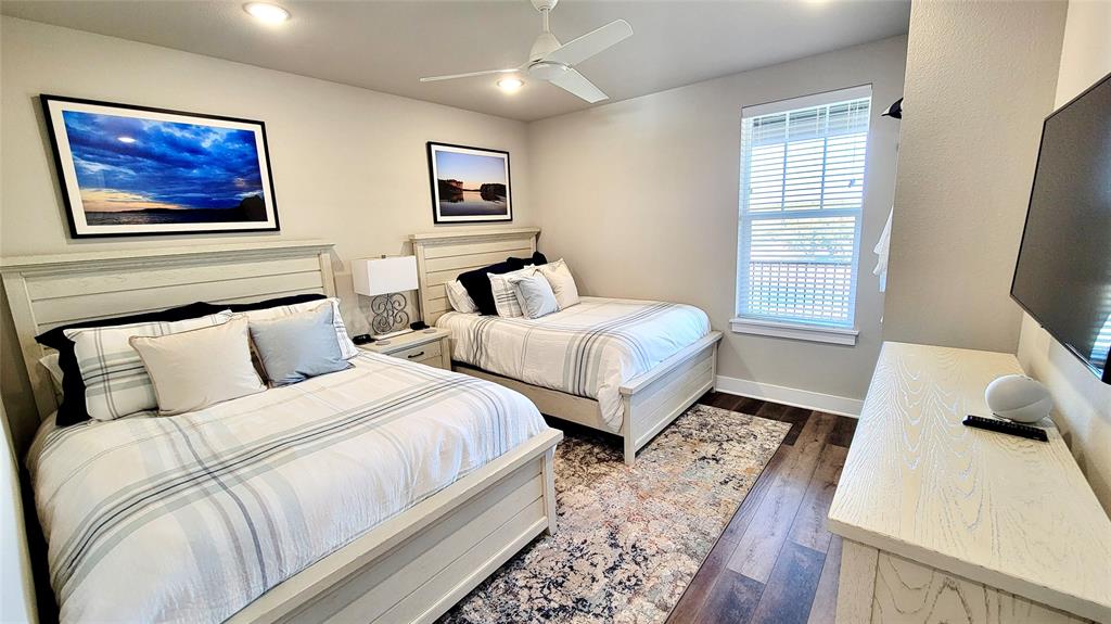 3412 Scenic Point Road, Unit 305 Graford, TX 76449 - Photo 11 of 37 a bedroom with two beds and painting on the wall