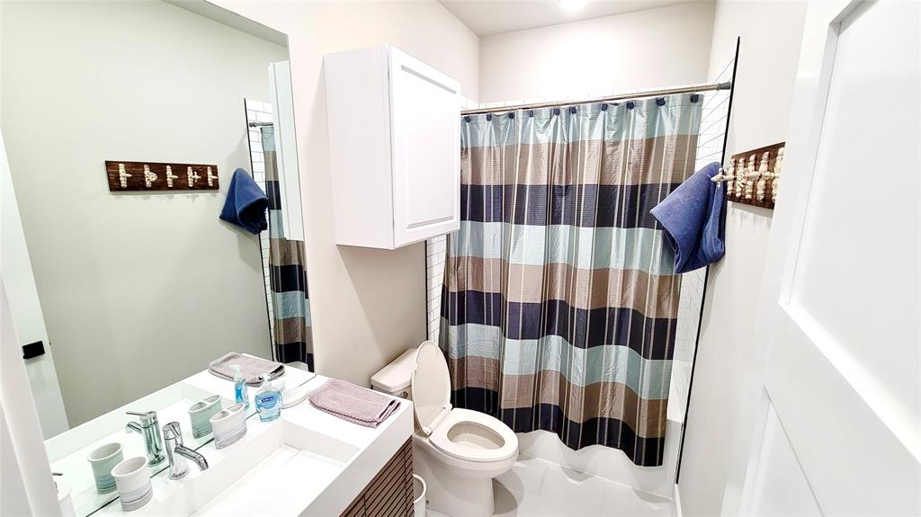 3412 Scenic Point Road, Unit 305 Graford, TX 76449 - Photo 13 of 37 a bathroom with a sink toilet and shower curtain