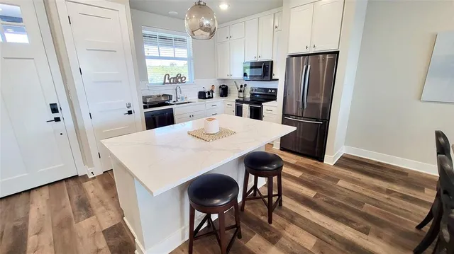 a living room with furniture and a dining table with wooden floor