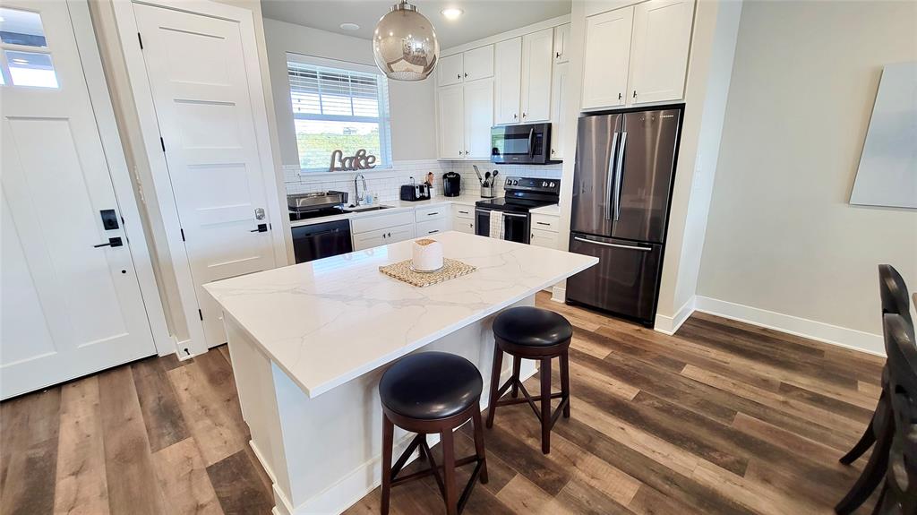 3412 Scenic Point Road, Unit 305 Graford, TX 76449 - Photo 3 of 37 a kitchen with stainless steel appliances a dining table chairs and refrigerator