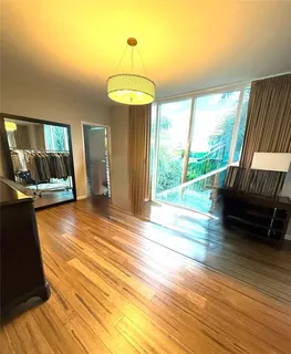 a view of a room with wooden floor lounge chair and windows