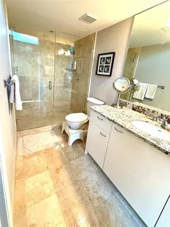 a bathroom with a granite countertop sink toilet and shower