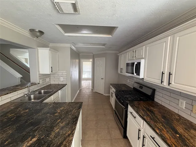 a kitchen with stainless steel appliances granite countertop a stove and a sink