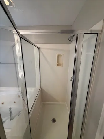 a bathroom with a glass door shower and toilet