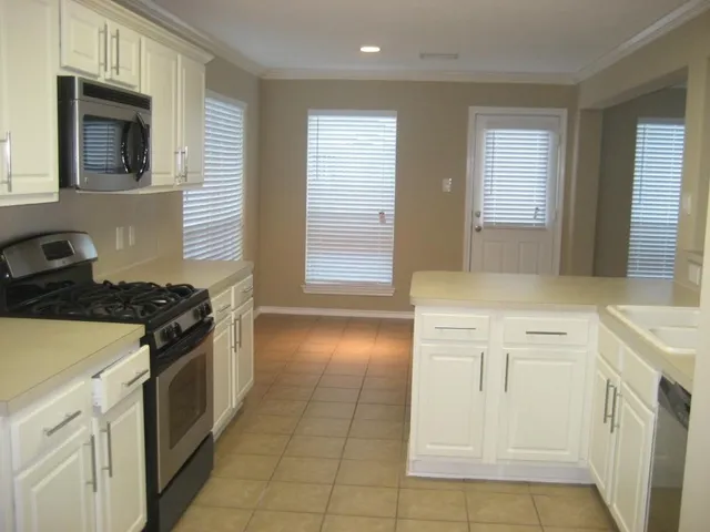 a kitchen with a stove sink and cabinets