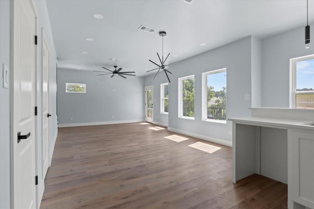 1116 East Oleander Street Fort Worth, TX 76104 - Photo 11 of 32 a view of an empty room with a window and wooden floor