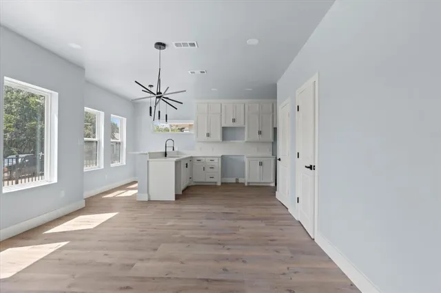 a view of a kitchen with wooden floor a sink and windows