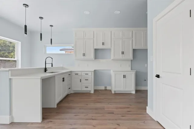 a kitchen with white cabinets and sink