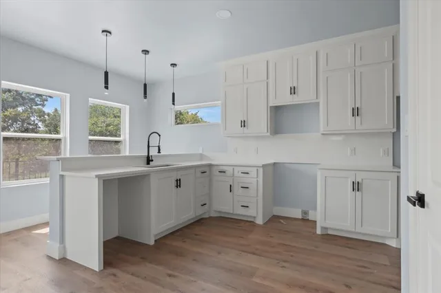 a kitchen with white cabinets and window