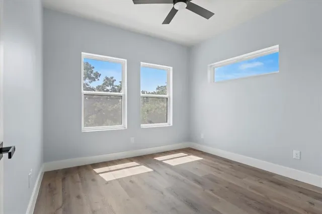 a view of empty room with wooden floor and window