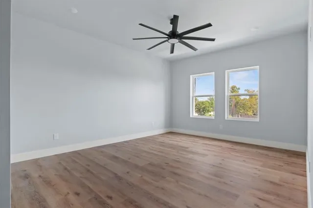 a view of a big room with wooden floor and windows