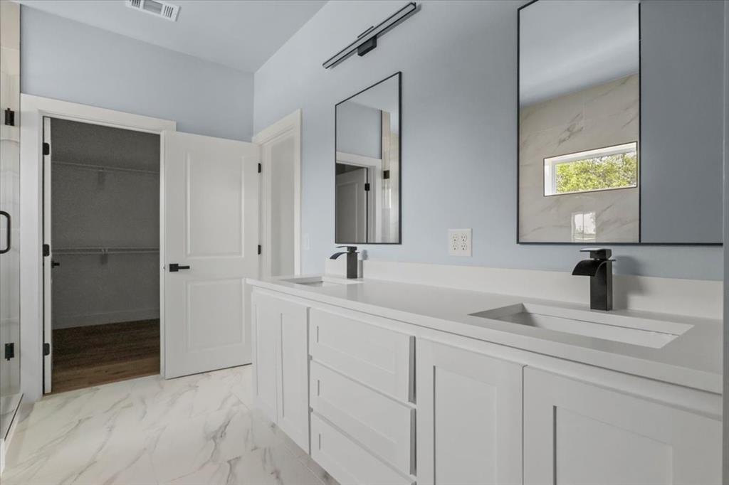 1116 East Oleander Street Fort Worth, TX 76104 - Photo 26 of 32 a bathroom with double sink and a mirror
