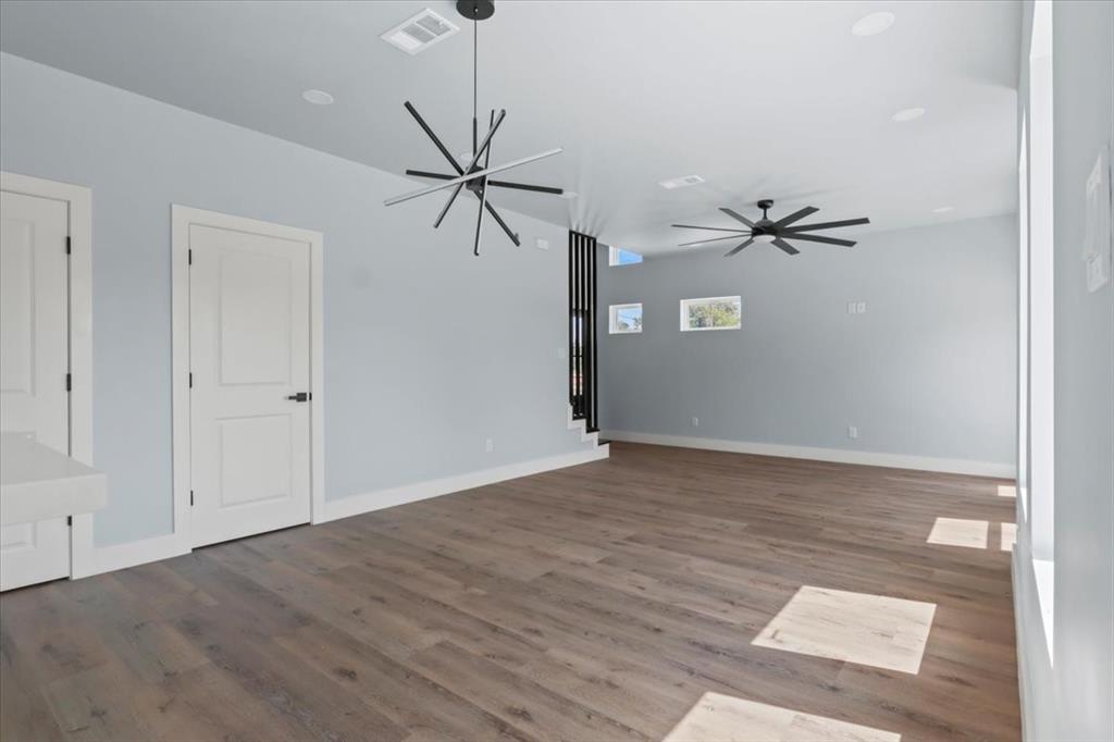1116 East Oleander Street Fort Worth, TX 76104 - Photo 10 of 32 a view of a room with a ceiling fan and a wooden floor