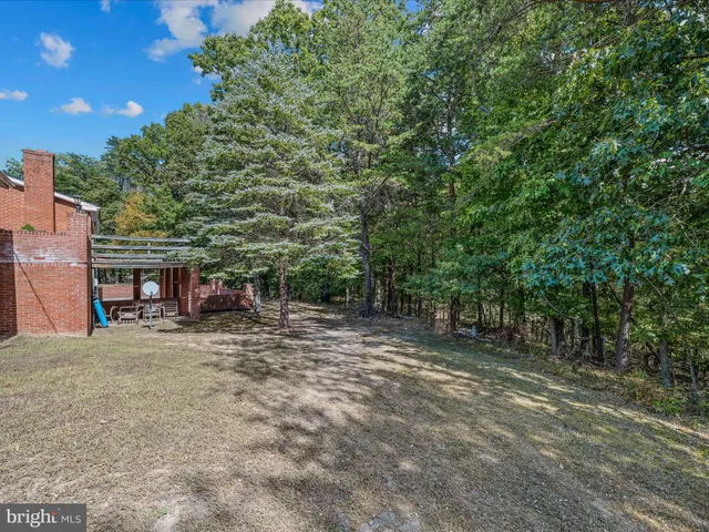 a front view of house with yard and trees in the background