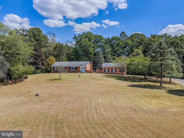 a view of a hallway with wooden floor and a bathroom