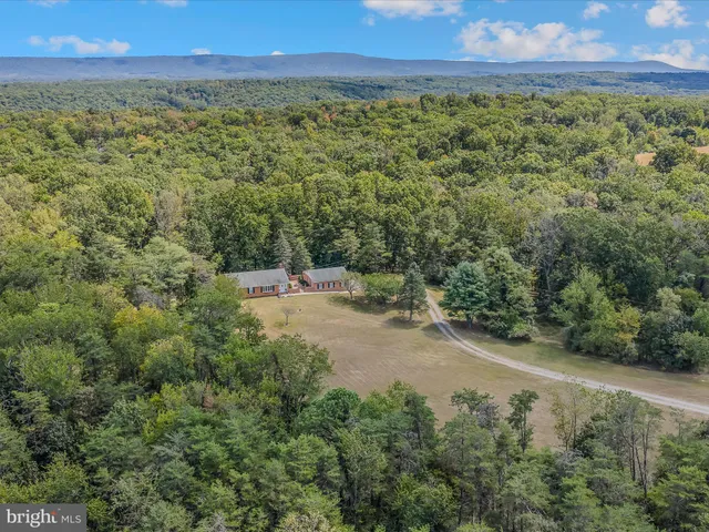 an aerial view of house with yard and mountain in back